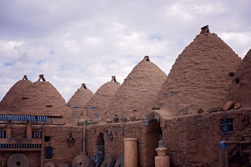 Traditional mud-brick structures with conical roofs, possibly a historical site or village. 1