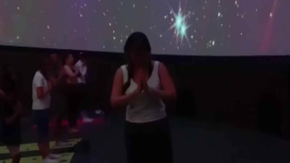 A person in a white tank top clapping hands. 2