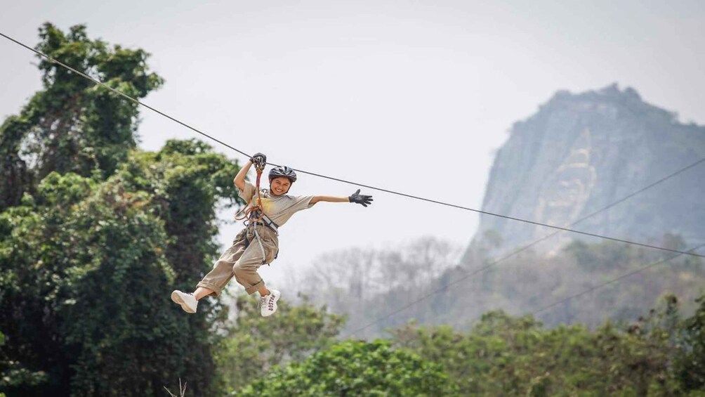 A person zip-lining with a mountainous landscape in the background. 5