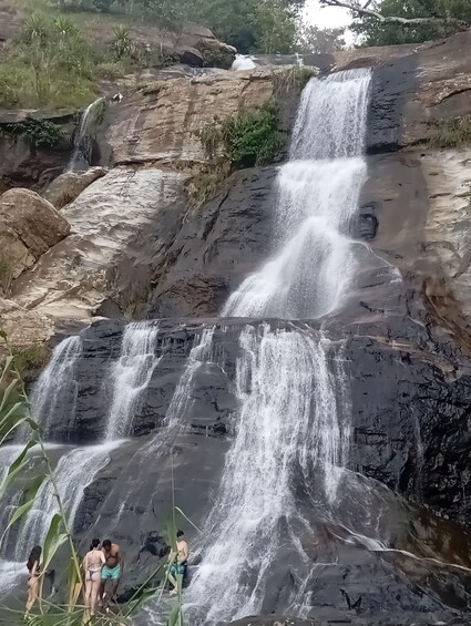 A multi-tiered waterfall surrounded by rocky terrain and greenery. 5