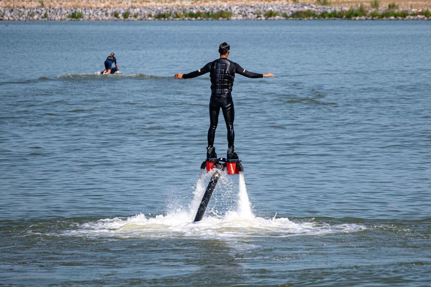 A person water skiing on a lake with another person in the background. 3