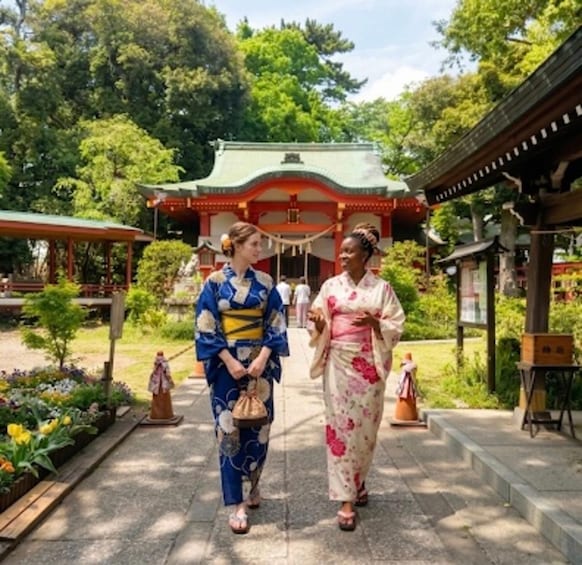 Two individuals in traditional Japanese kimonos walking towards a temple with a green roof. 1