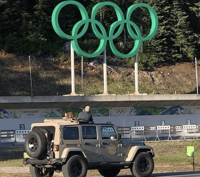 A vehicle parked in front of an Olympic rings sign with a 'vancouver 2010' backdrop. 5