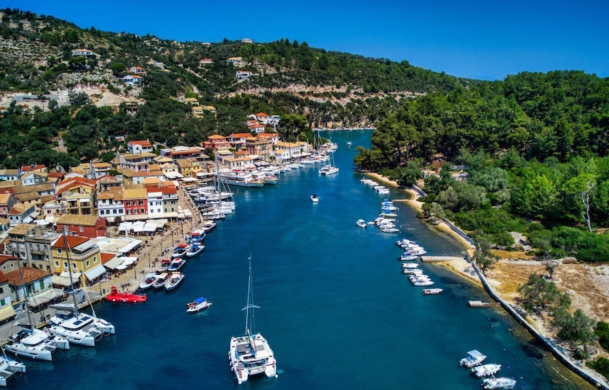 A coastal town with a marina filled with boats, surrounded by hills and dense greenery. 4