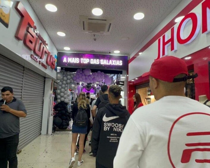Un couloir d’un centre commercial, avec des boutiques comme « Taurus » et « JHOT ». 4