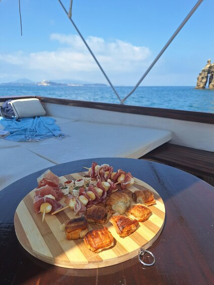 Een houten plank met verschillende soorten eten op een boot. 2