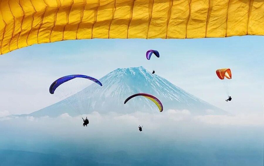 Et bjerg med mennesker som paraglider i baggrunden. 1