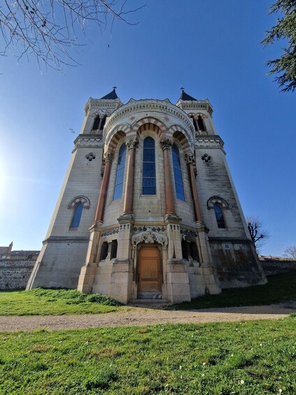 A historic building with a large arched entrance, tall columns, and a clock tower. 3