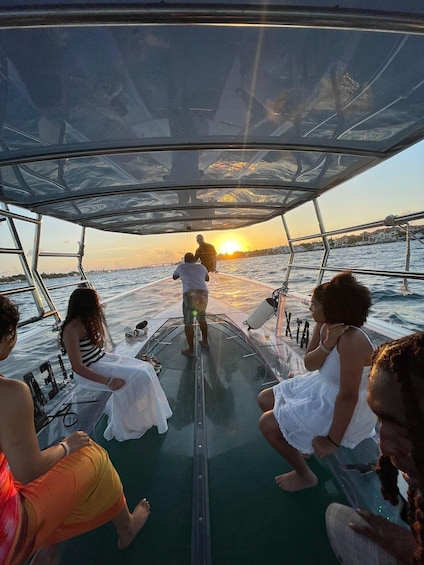 A boat with people on deck during sunset. 4