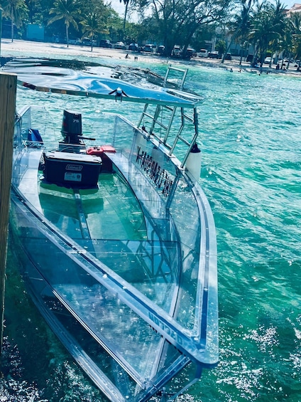 A boat with 'KAHARATAN' written on it, floating on clear turquoise water. 3