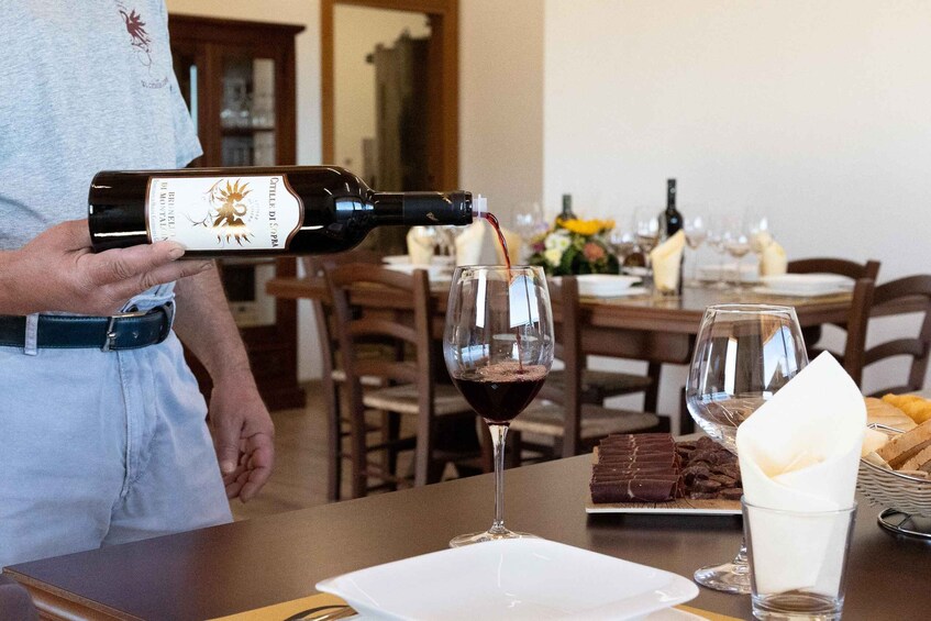 A person pouring wine into a glass. 3