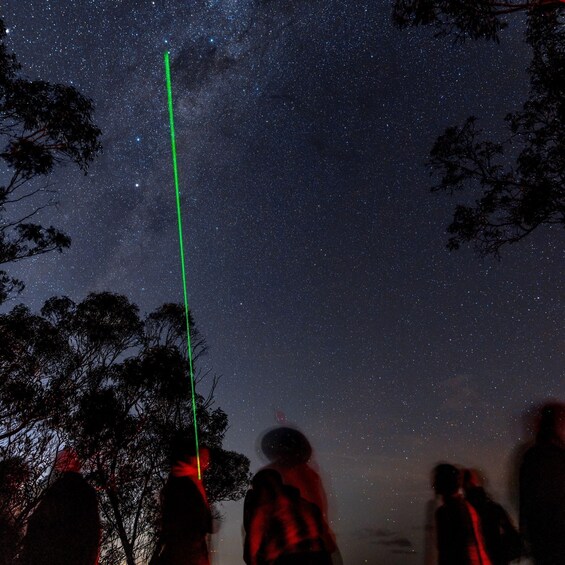 A starry night sky with a green laser beam. 2