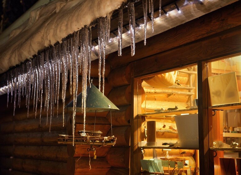 Icicles hanging from a wooden ceiling, a window with a view of a room, and a hanging lantern. 5