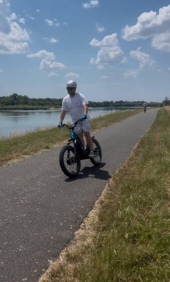 A person riding a Segway on a paved path alongside a body of water. 4