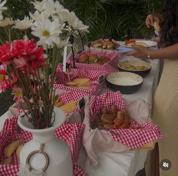 A picnic table with food and flowers. 5