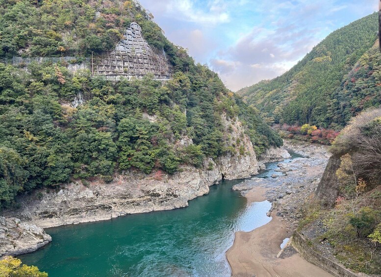 A river flowing through a valley with a temple on a hillside. 3