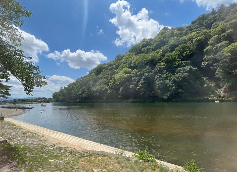 A calm river with a wooden dock, surrounded by lush greenery and a clear sky. 4