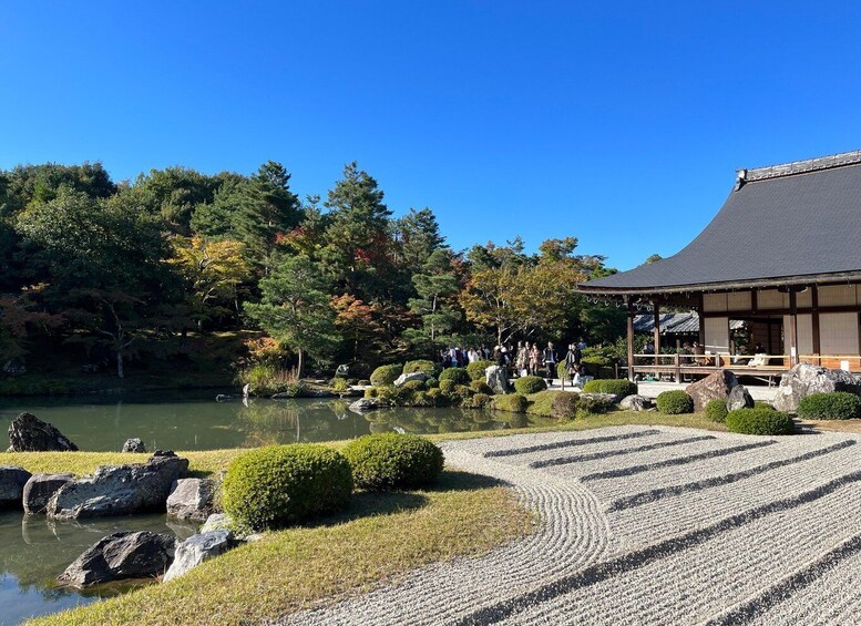 A traditional Japanese garden with a pond, rocks, and a wooden building. 5