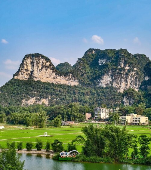 A mountainous landscape with a river, green fields, and buildings. 5
