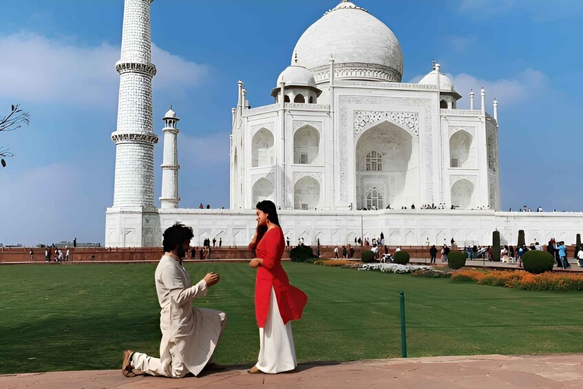 A man kneeling and proposing to a woman in front of the Taj Mahal. 3