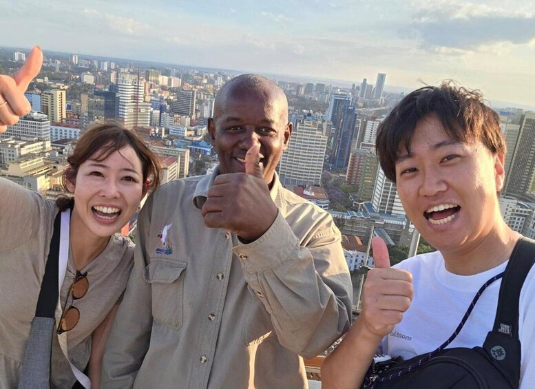 Three people giving thumbs up with a cityscape in the background. 3