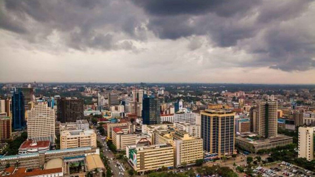 A cityscape with various buildings under a cloudy sky. 1