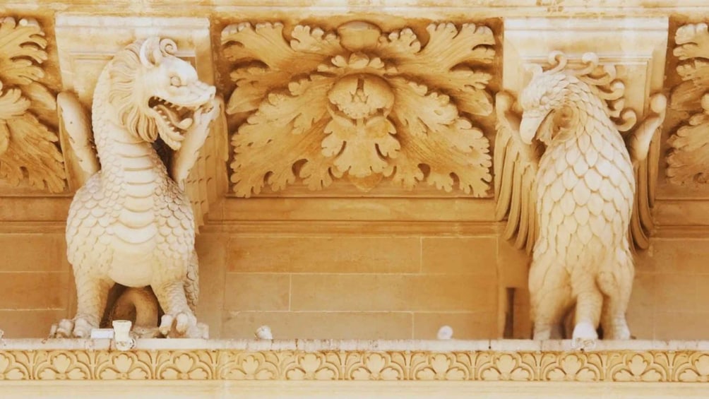 A detailed stone carving of two mythical creatures, possibly dragons, with intricate patterns and a central decorative motif. 3