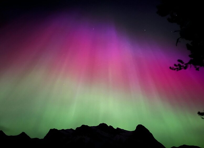 A night sky with aurora borealis over a mountain range. 1