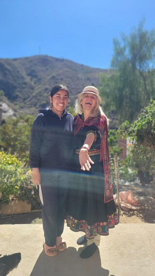 Two people standing outdoors with a mountainous backdrop. 5