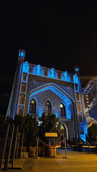A large, intricately designed building with blue lighting at night. 4