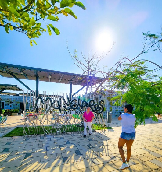 A sunny outdoor area with a sign reading 'Monteros del Rio' and a metal sculpture. 2