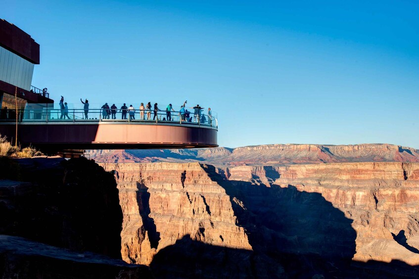 A glass bridge over a canyon with people walking on it. 3