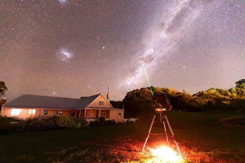 A house under a starry night sky with a telescope aimed at the Milky Way. 5
