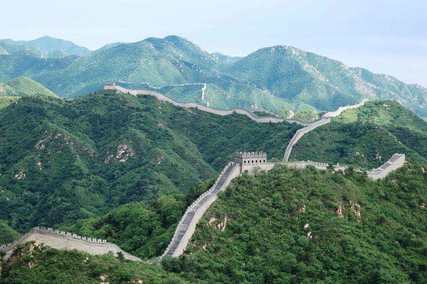 The Great Wall of China winding through lush green mountains. 3