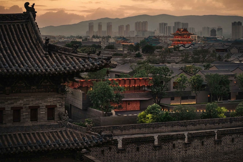 A traditional Chinese building with ornate roofs, surrounded by modern high-rise buildings and lush greenery. 5