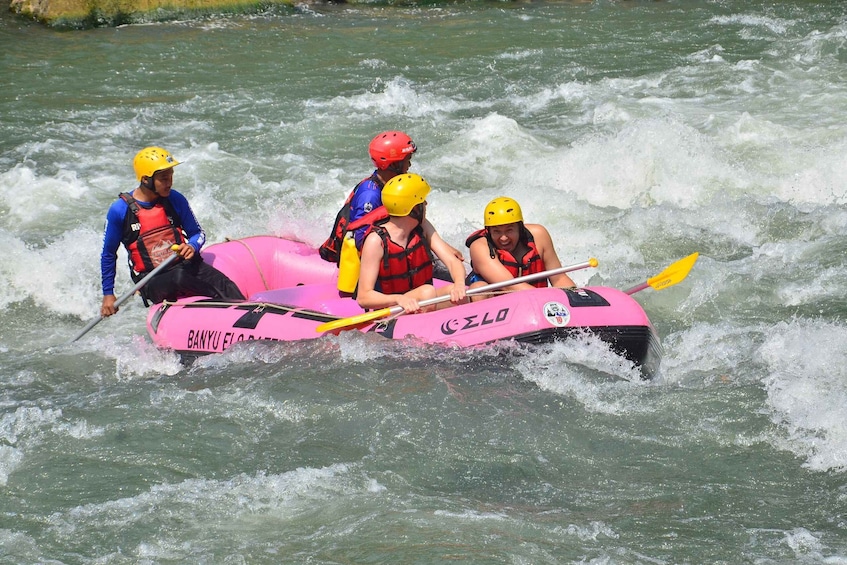 A group of people rafting on a pink inflatable raft with 'BANYU' and 'ZELLO' logos. 2