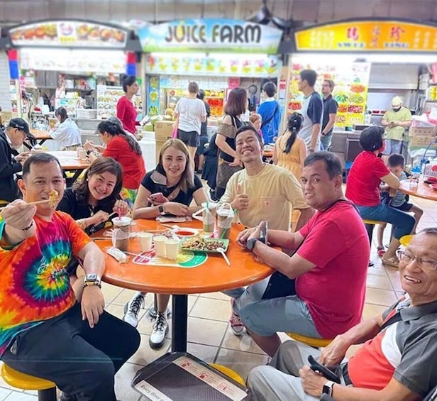 A group of people dining at a restaurant with a visible 'Juice Farm' sign in the background. 1