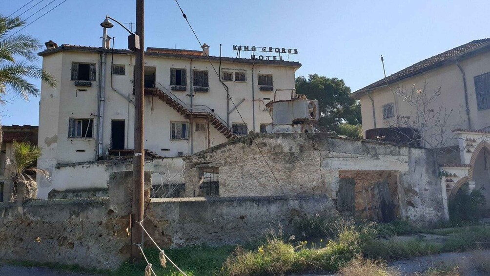 A building with a sign reading 'King George Hotel' and a staircase leading to a door. 3