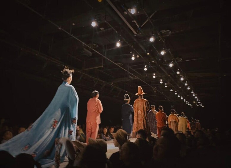 A fashion runway with models walking down it. 5