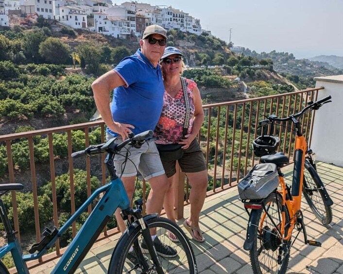A couple standing on a balcony with bicycles. 2
