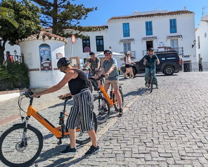 A group of people riding bicycles on a cobblestone street. 3