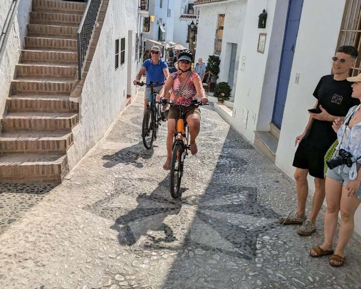 A narrow cobblestone street with cyclists and pedestrians. 4