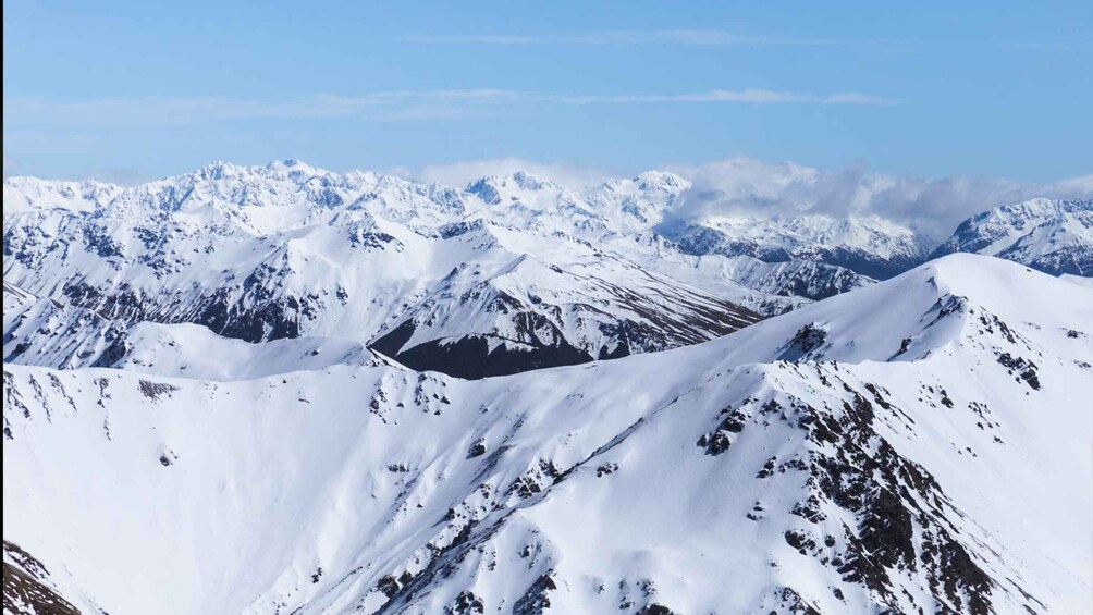 A snow-covered mountain range with rugged peaks and valleys. 4