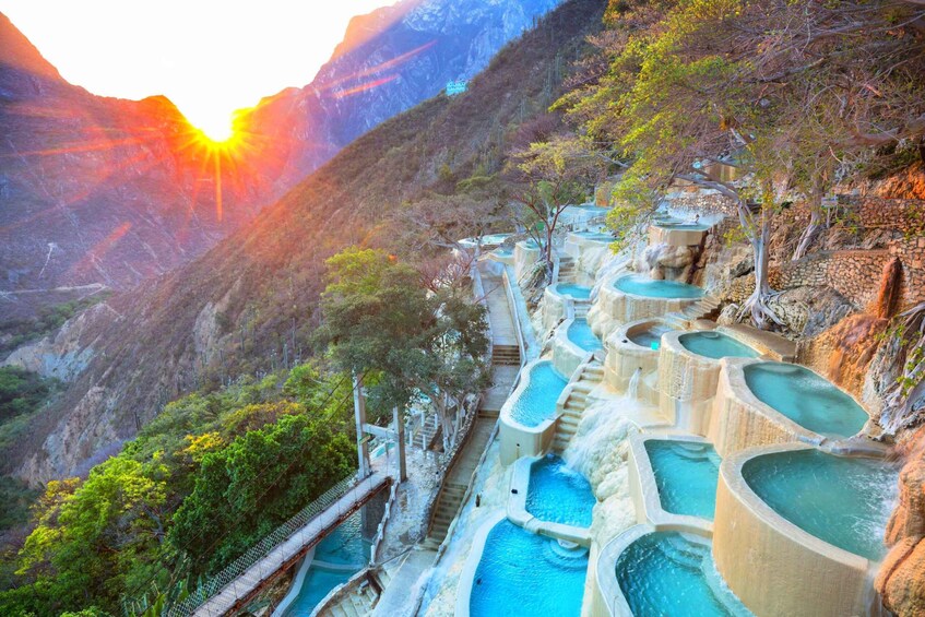 Terraced pools in a mountainous landscape with a sunset. 1
