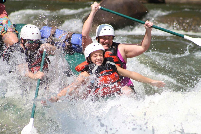People in a raft navigating through a river with splashes. 1
