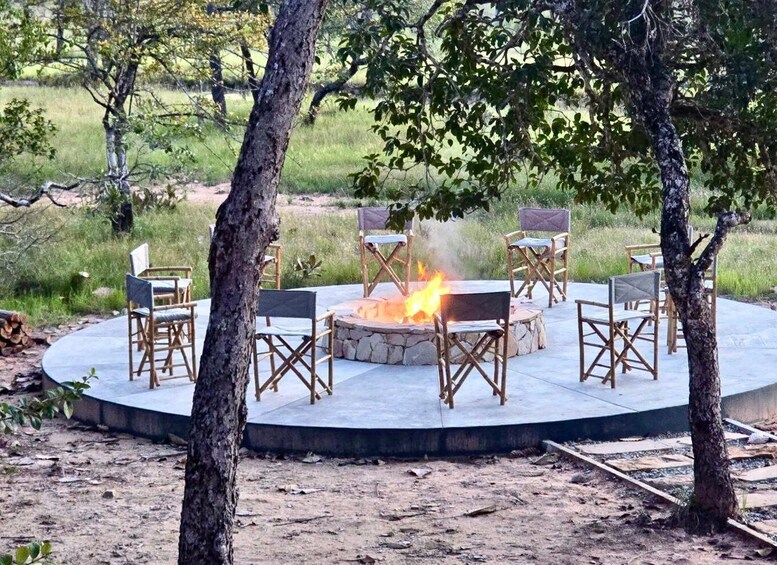 An outdoor seating area with a fire pit surrounded by chairs. 1