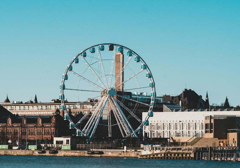 A large Ferris wheel by a waterfront with historic buildings in the background. 5