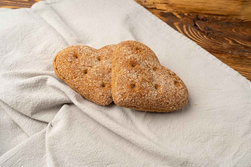 Two heart-shaped cookies on a cloth. 4