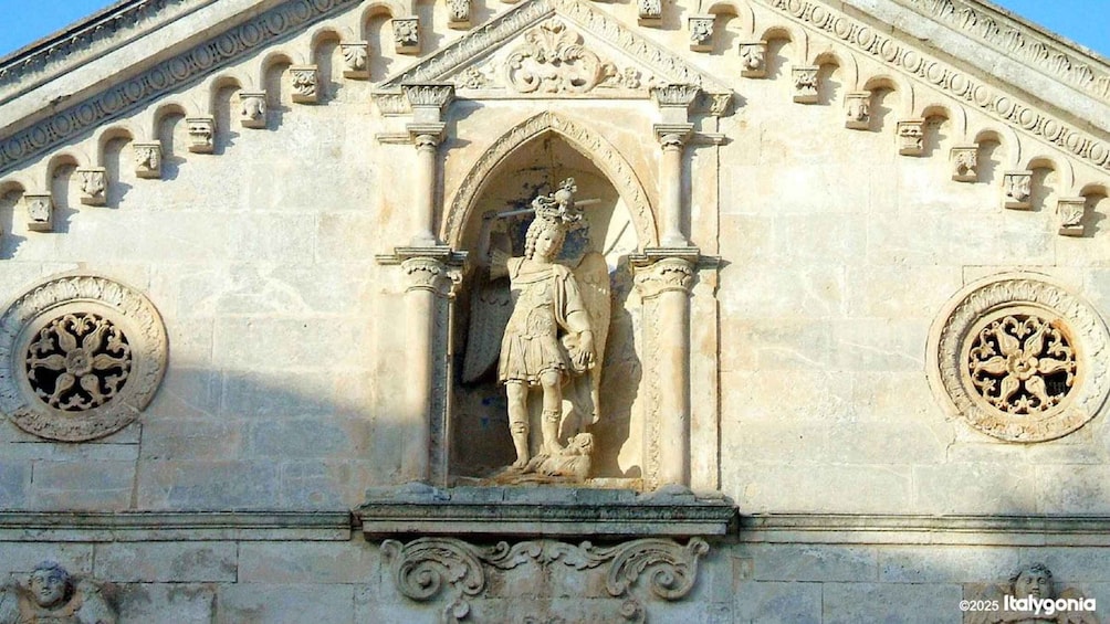 A stone facade with a central arched doorway, flanked by columns and decorative moldings. 3