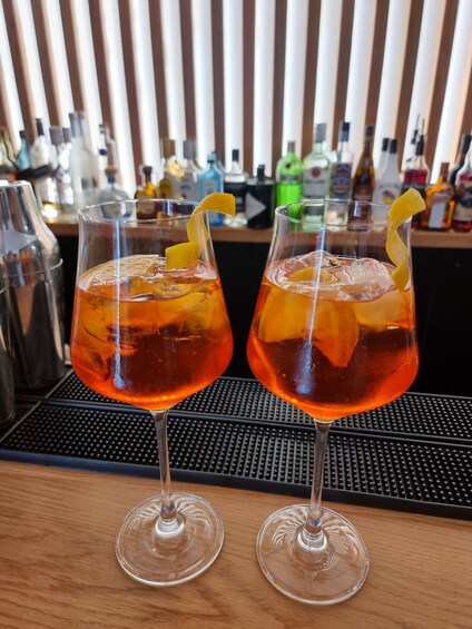 Two cocktails with orange slices on a bar counter. 5